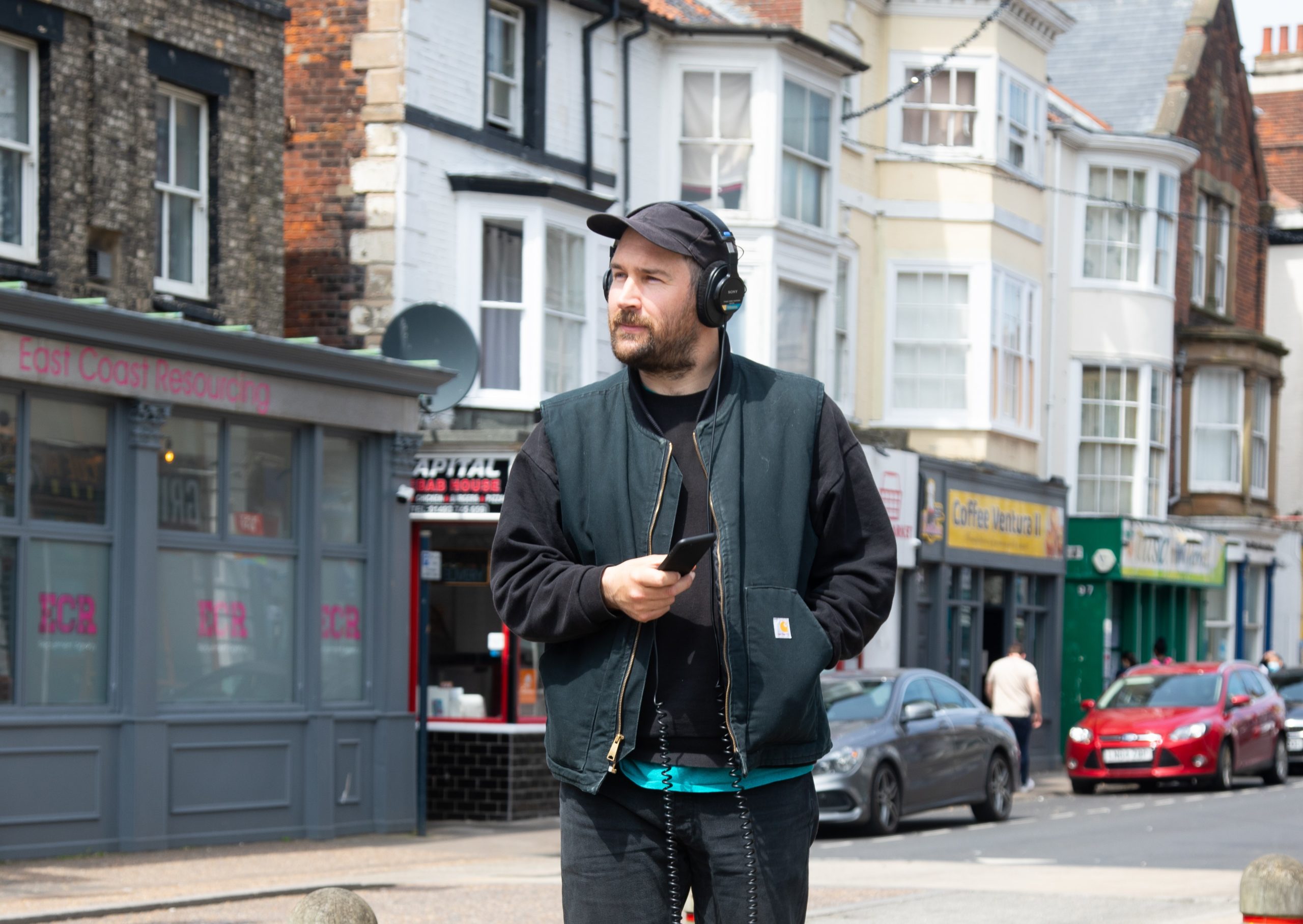 Image of sound artist Oliver Payne walking along Great Yarmouth High Street.